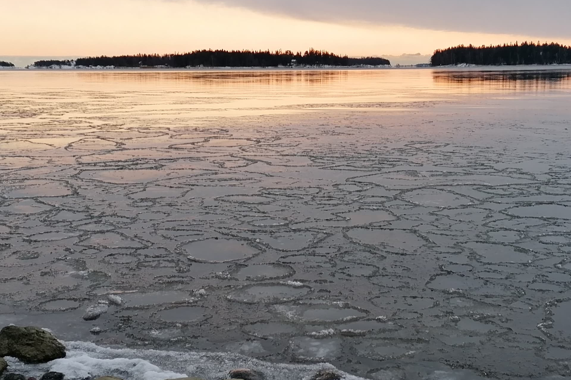 Talvinen merimaisema. Meren pinta on jäässä. Auringonlasku.
